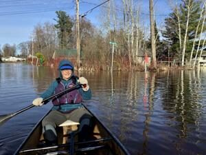 Lake Mitchell resident surveys flood carnage on canoe
